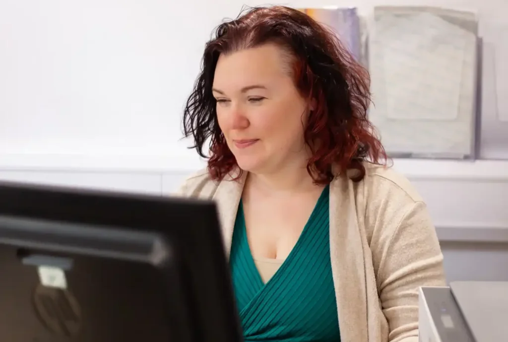 Helena Clinkscales, founder of Optimised Office, smiling at her desk